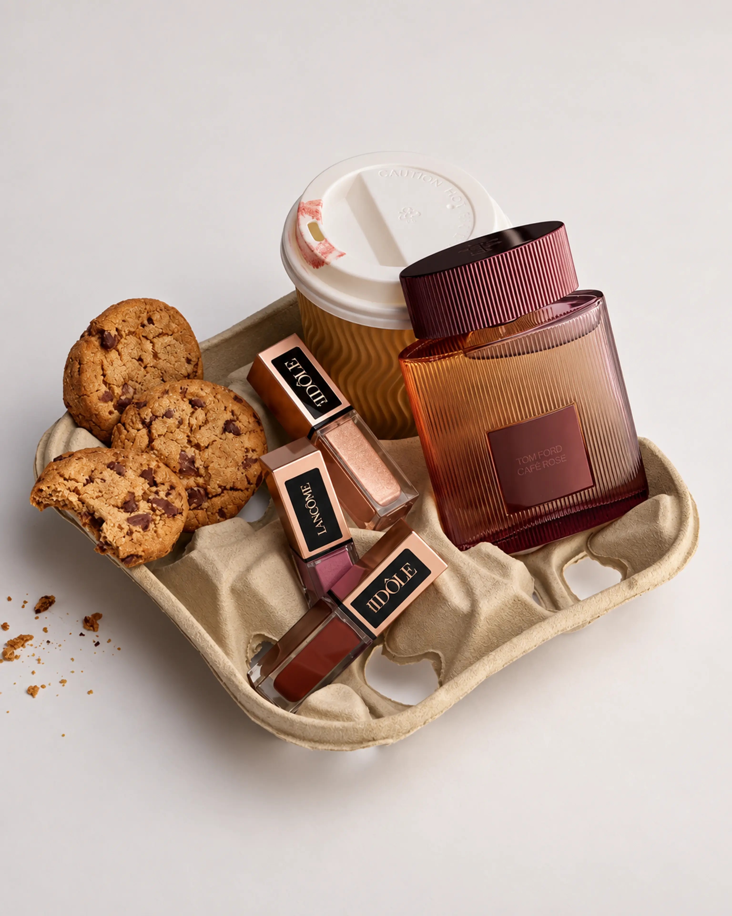 Coffee, cookies, and brown accessories arranged on a warm neutral tray