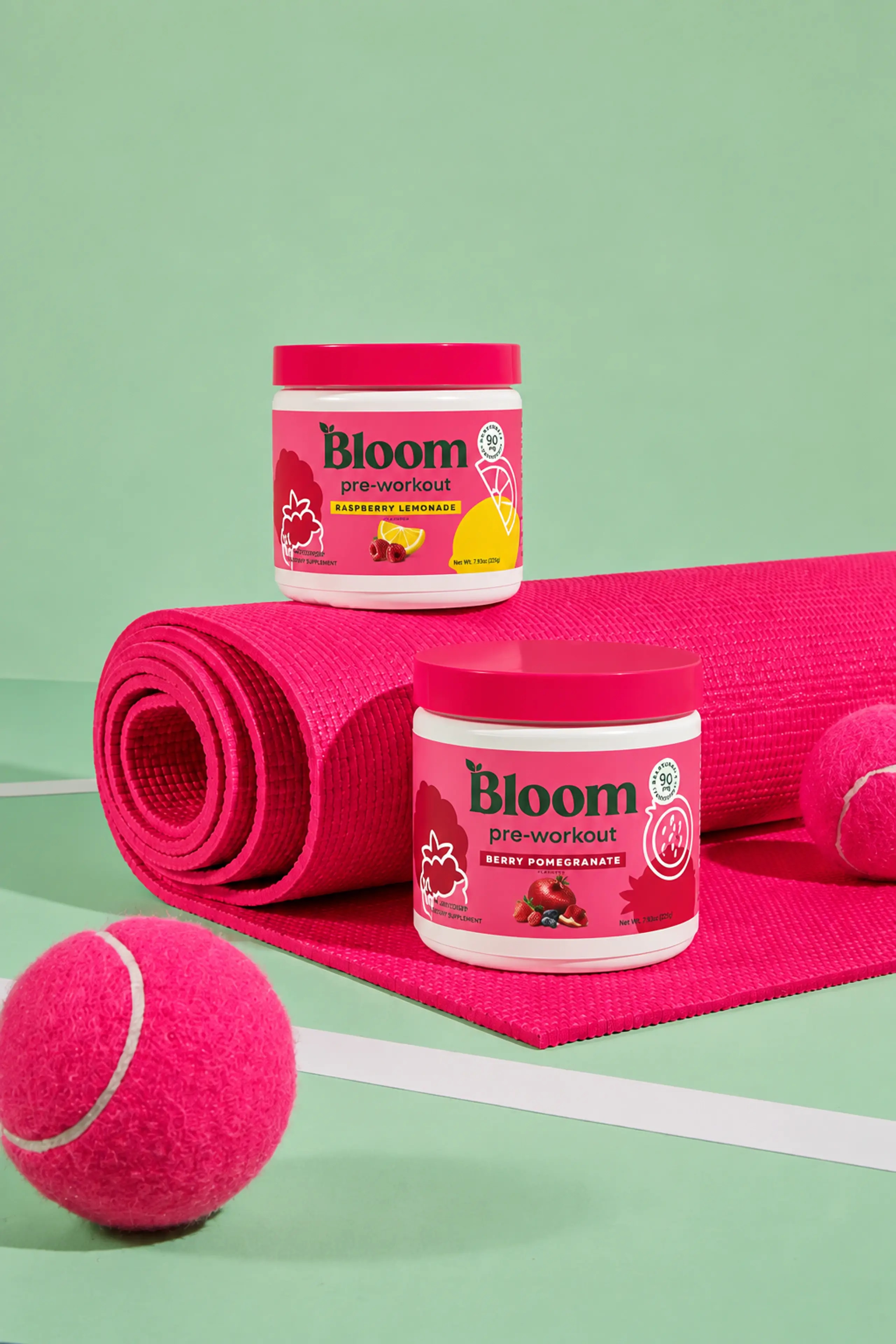 Bright pink sporting accessories against a sage green tennis court