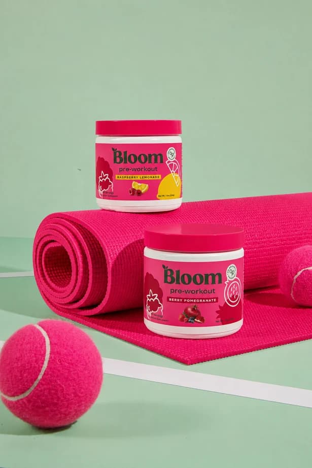 Bright pink sporting accessories against a sage green tennis court