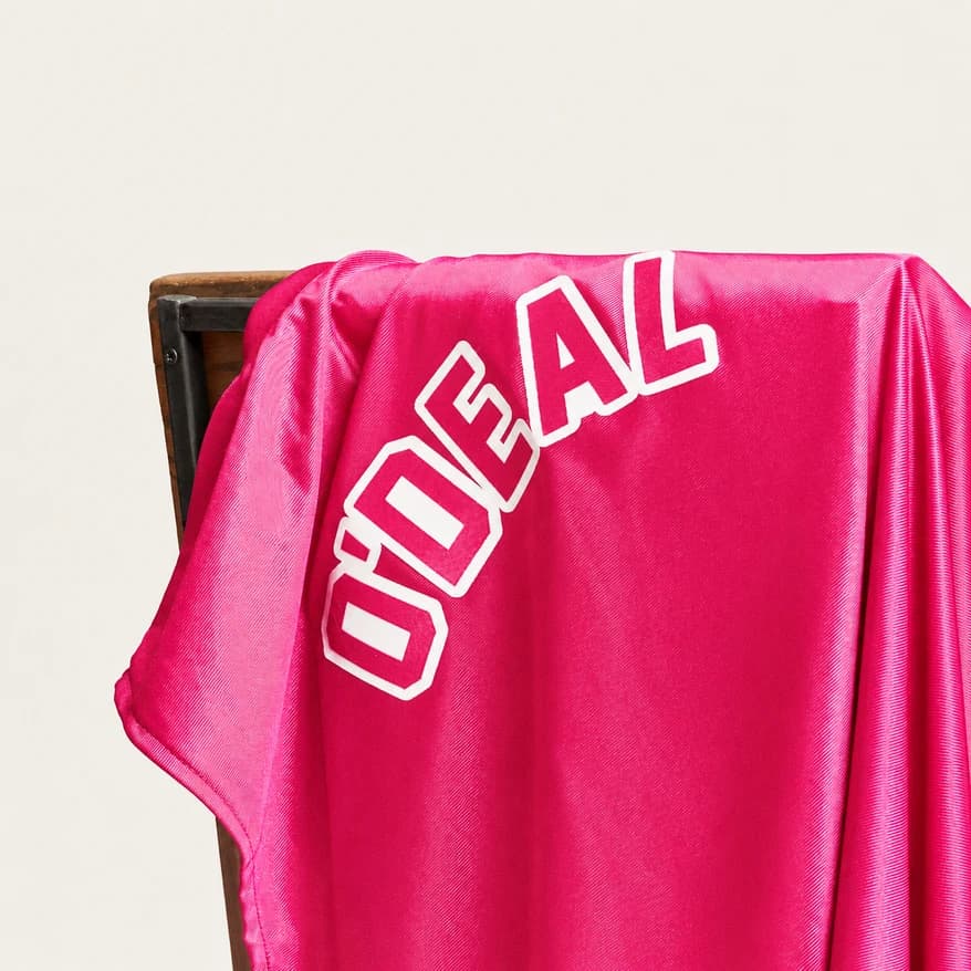 A bright pink shirt draped over a wooden chair